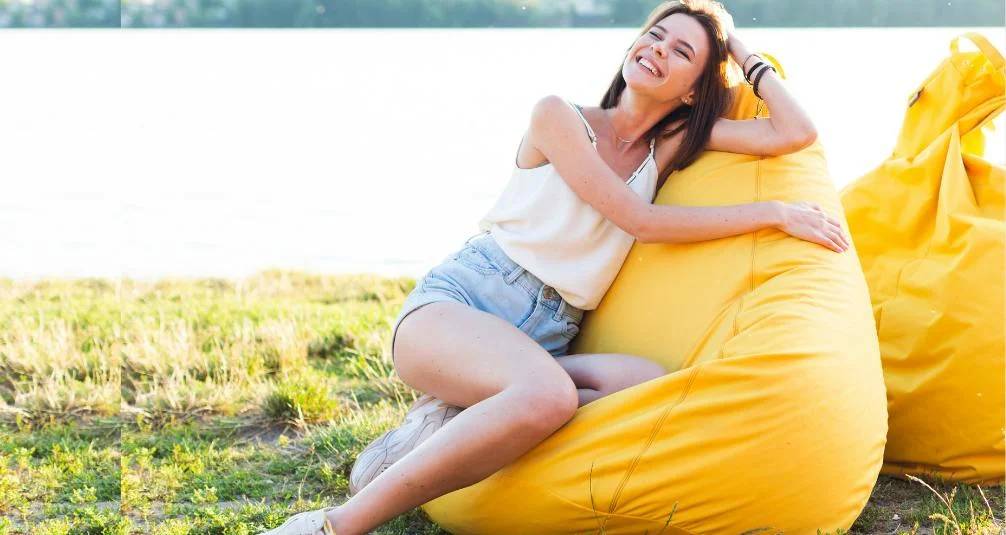 Woman on yellow beanbag outdoors